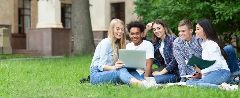 Groupe d'étudiants utilisant un ordinateur portable en plein air.