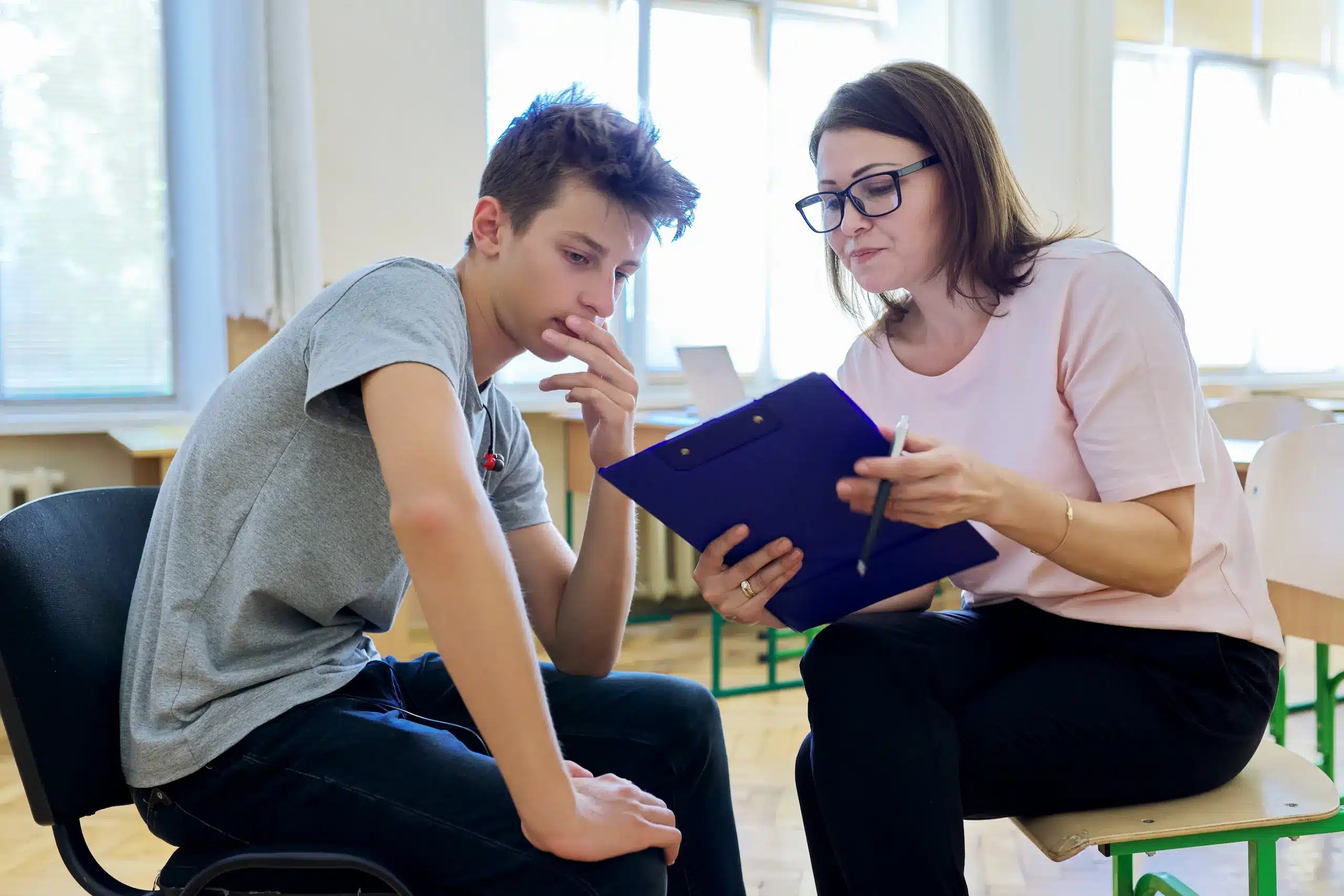 Un adolescent et un enseignant en discussion.