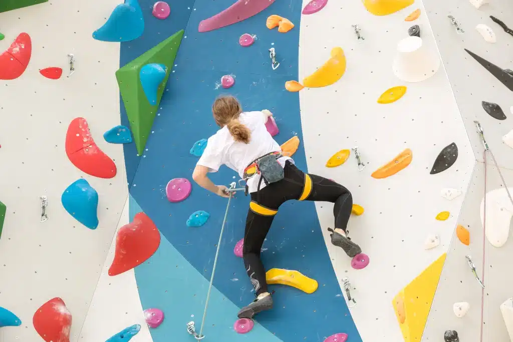 Personne grimpe sur un mur d'escalade coloré.