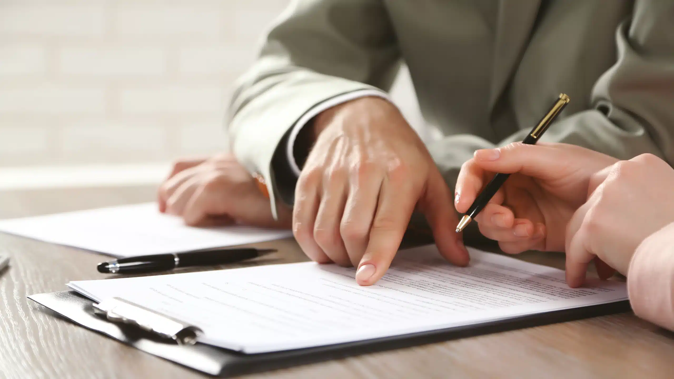 Deux personnes signent des documents ensemble.